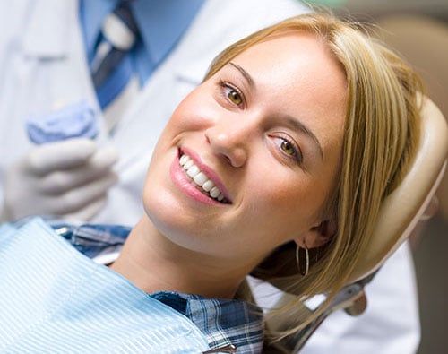 woman smiling in a dental chair with her face turned to the camera
